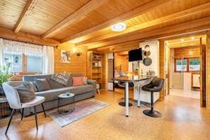 Ein gemütliches Blockhausschlafzimmer mit einer Couch, einem Esstisch und Stühlen.