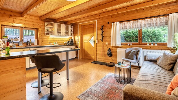A wooden cabin interior with a kitchen, dining area, and living room. - Holiday Home 'Haus Grün' suitable for wheelchairs (Scheibenberg)