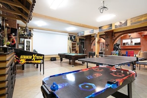 Ein Billardraum mit Pool-, Kicker- und Tischtennistischen.