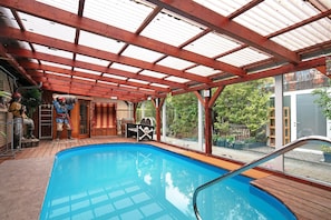 Ein Hallenbad mit Holzterrasse, überdachtem Bereich und Piratendekoration.