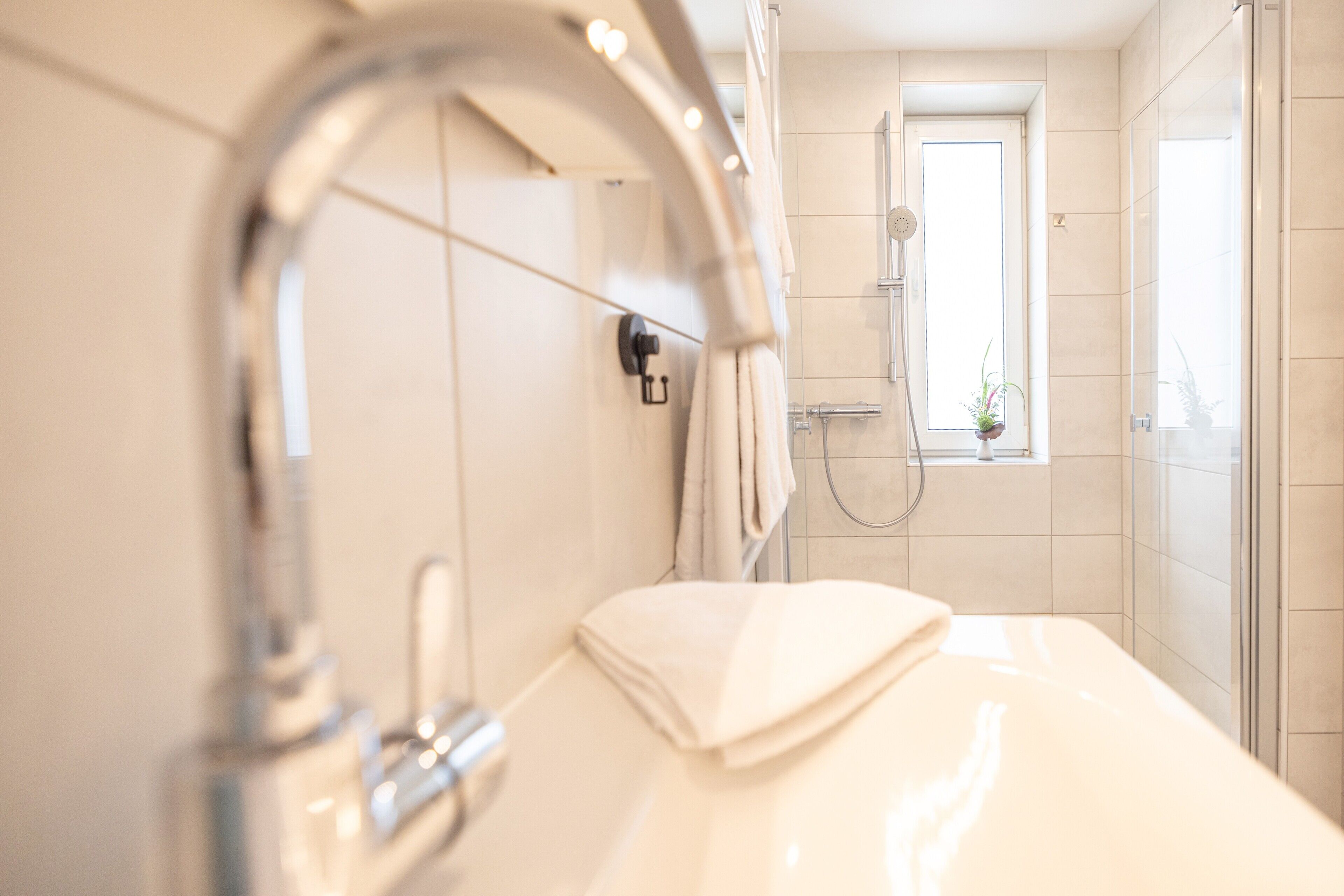 Ein Badezimmer mit Waschbecken, Spiegel und Dusche.