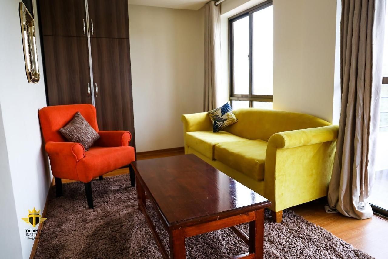 Un salon avec une table basse en bois, un fauteuil rouge et un canapé jaune.