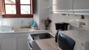 Eine Küche mit Spüle, Herd, Mikrowelle und einer Holz Arbeitsplatte.