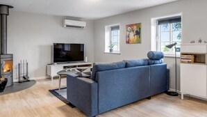 Uma sala de estar moderna com sofá, televisão, lareira e obras de arte.