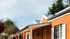 A row of brick houses with attached porches, each with a door and windows. - Riverview at Ross (Ross)