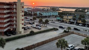 A multi-story building with a parking lot and a street view. - NEWLY RENOVATED-BEACH FRONT-TOP FLOOR-BRIGHT LIGHT-QUIET BUILDING (Gulf Shores)