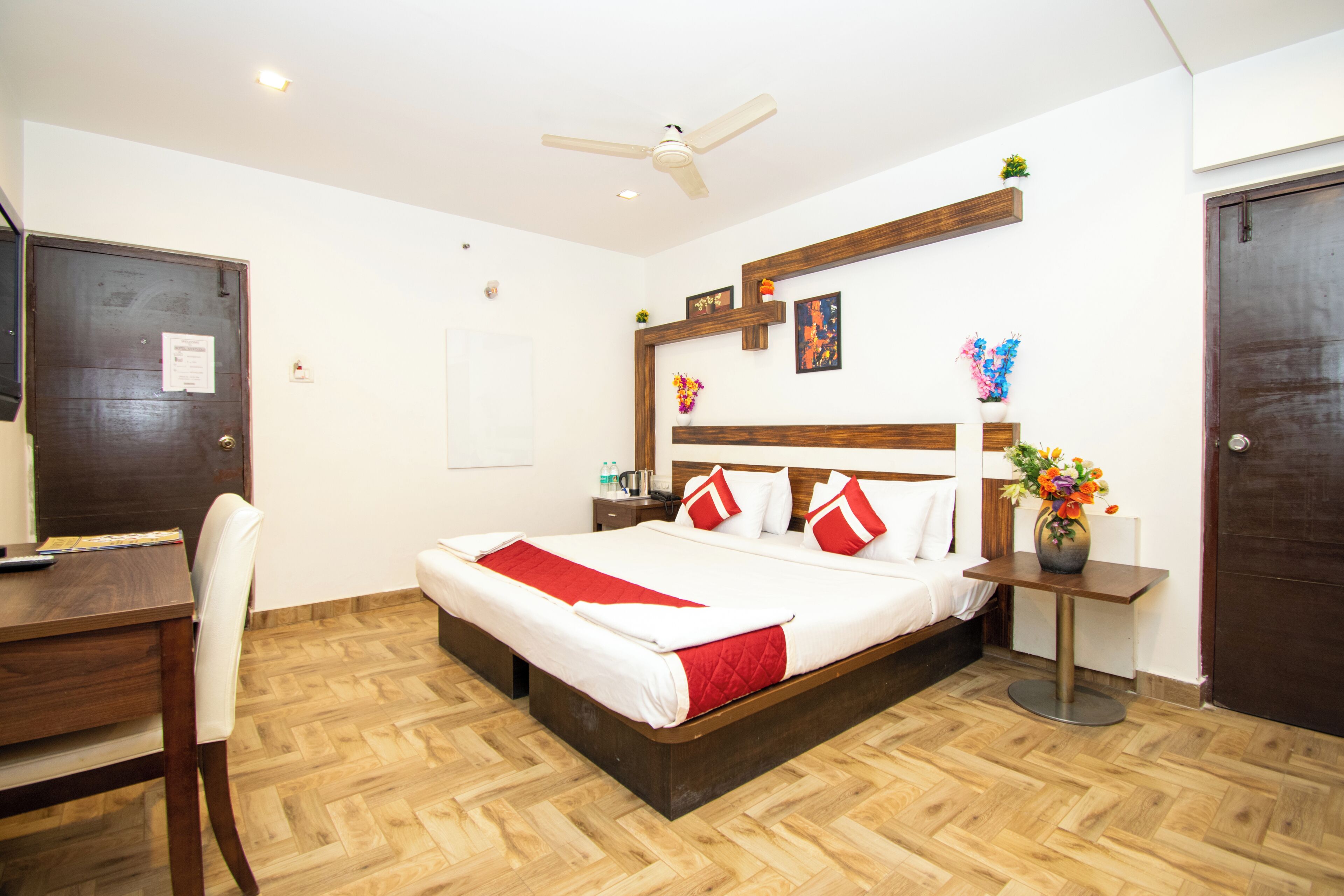 A hotel room with a wooden bed, a desk, and a chair.