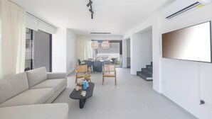 Un salon moderne avec un canapé, une table basse et un coin repas.
