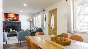 Un coin repas avec une table en bois, des chaises et une cheminée.
