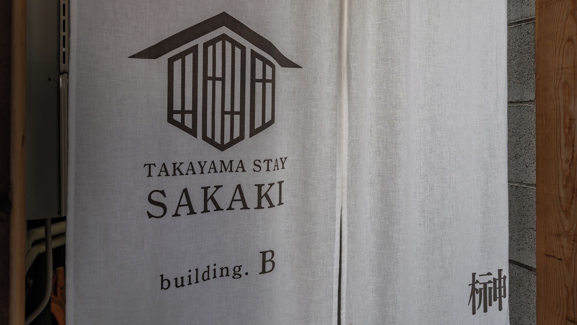 Ein Schild mit einem Gebäude-Symbol und dem Text 'TAKAYAMA STAY SAKAKI Gebäude. B'.