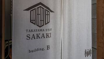 Ein Schild mit einem Gebäude-Symbol und dem Text 'TAKAYAMA STAY SAKAKI Gebäude. B'.