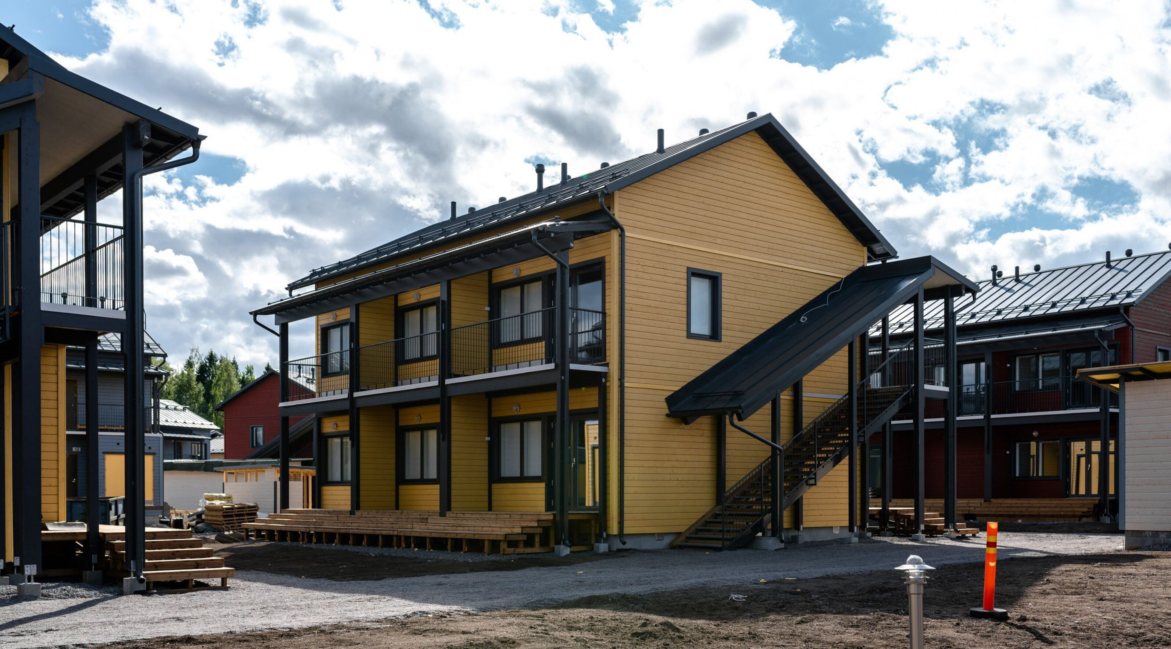A yellow building with a staircase and a balcony.