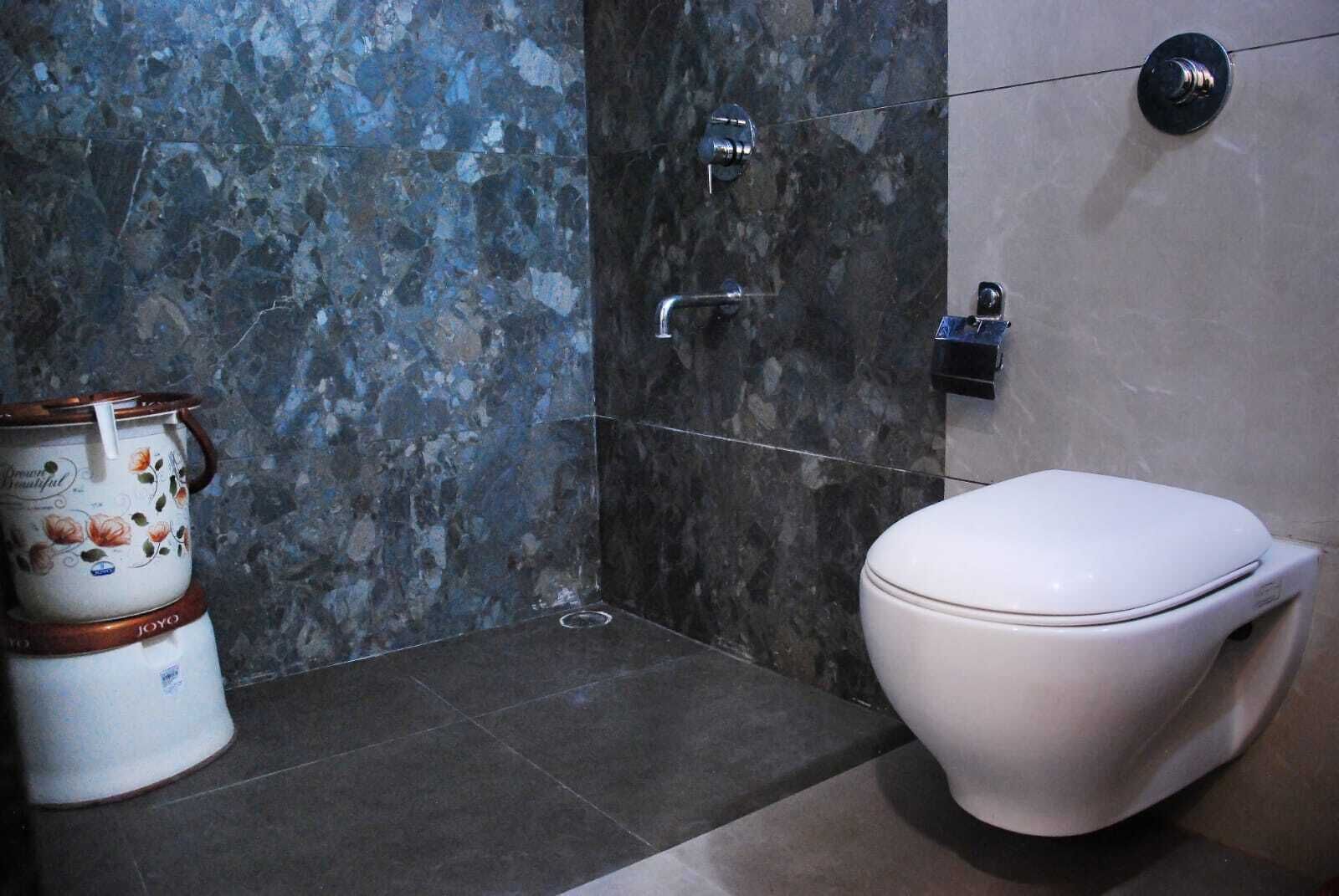 A bathroom with a toilet, a shower, and a decorative container.