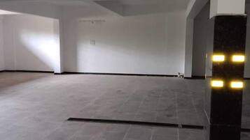 A spacious, empty room with a tiled floor and a black pillar with lights.
