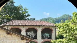 A building with a tiled roof, arched windows, and a gate. - Casale Milleseicento (Gavi)