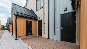 A row of modern buildings with wooden walkways and black doors. - Forenom Serviced Apts Vantaa Koivuhaka (Vantaa)