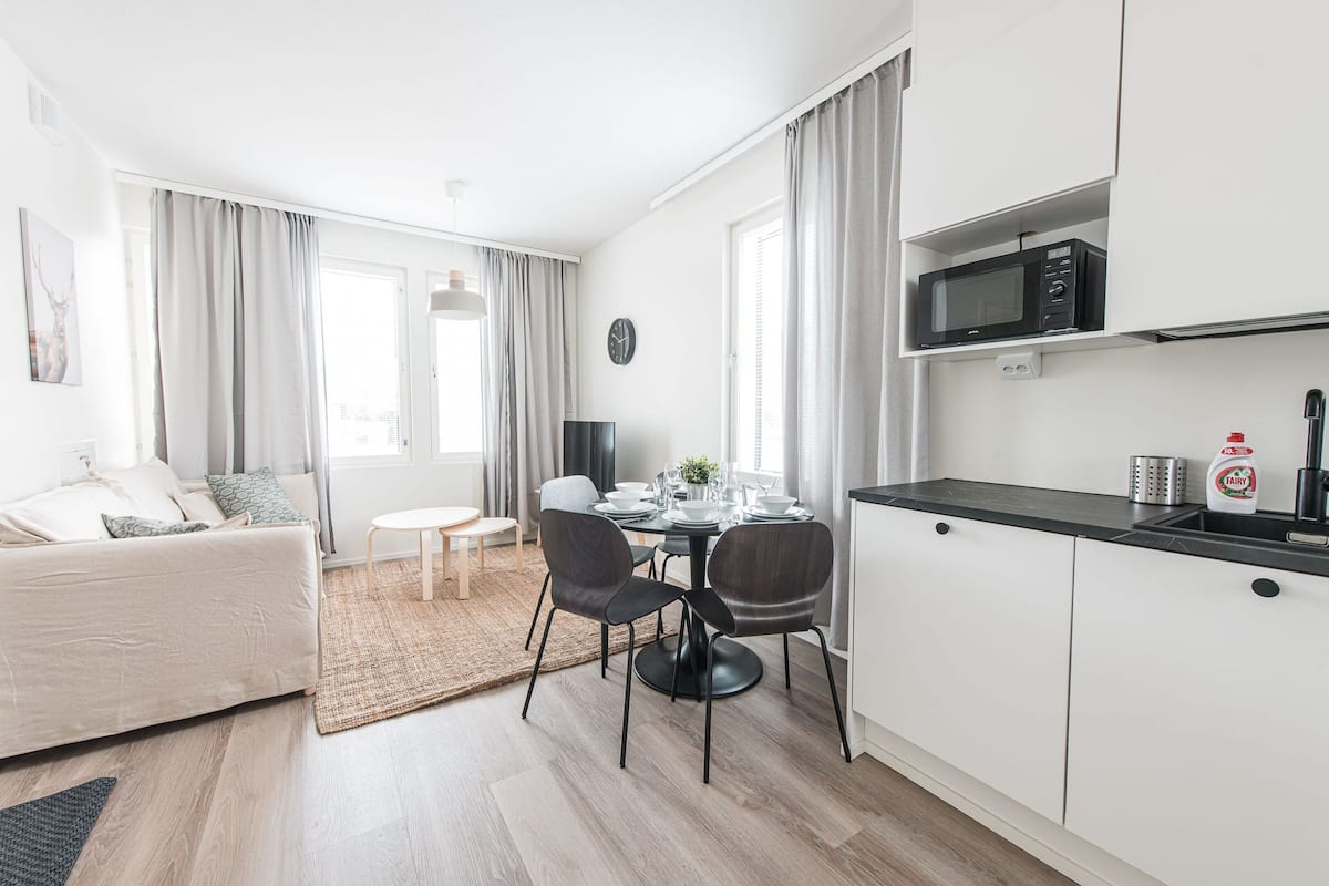 A modern apartment with a dining area, kitchen, and living space.