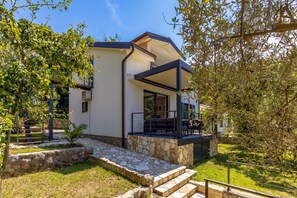 A modern house with a stone staircase leading to a covered outdoor seating area. - Beachside House Lara (Omisalj)