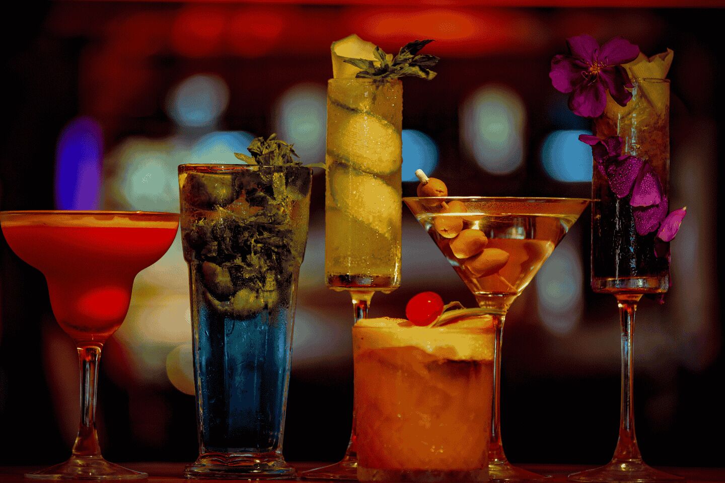 Fire forskellige cocktails i forskelligt glasværk.