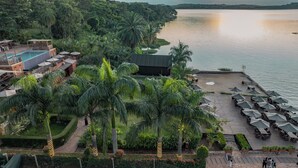 A resort with a pool, outdoor seating, and a view of the water. - Divine Resort & Spa (Kampala)