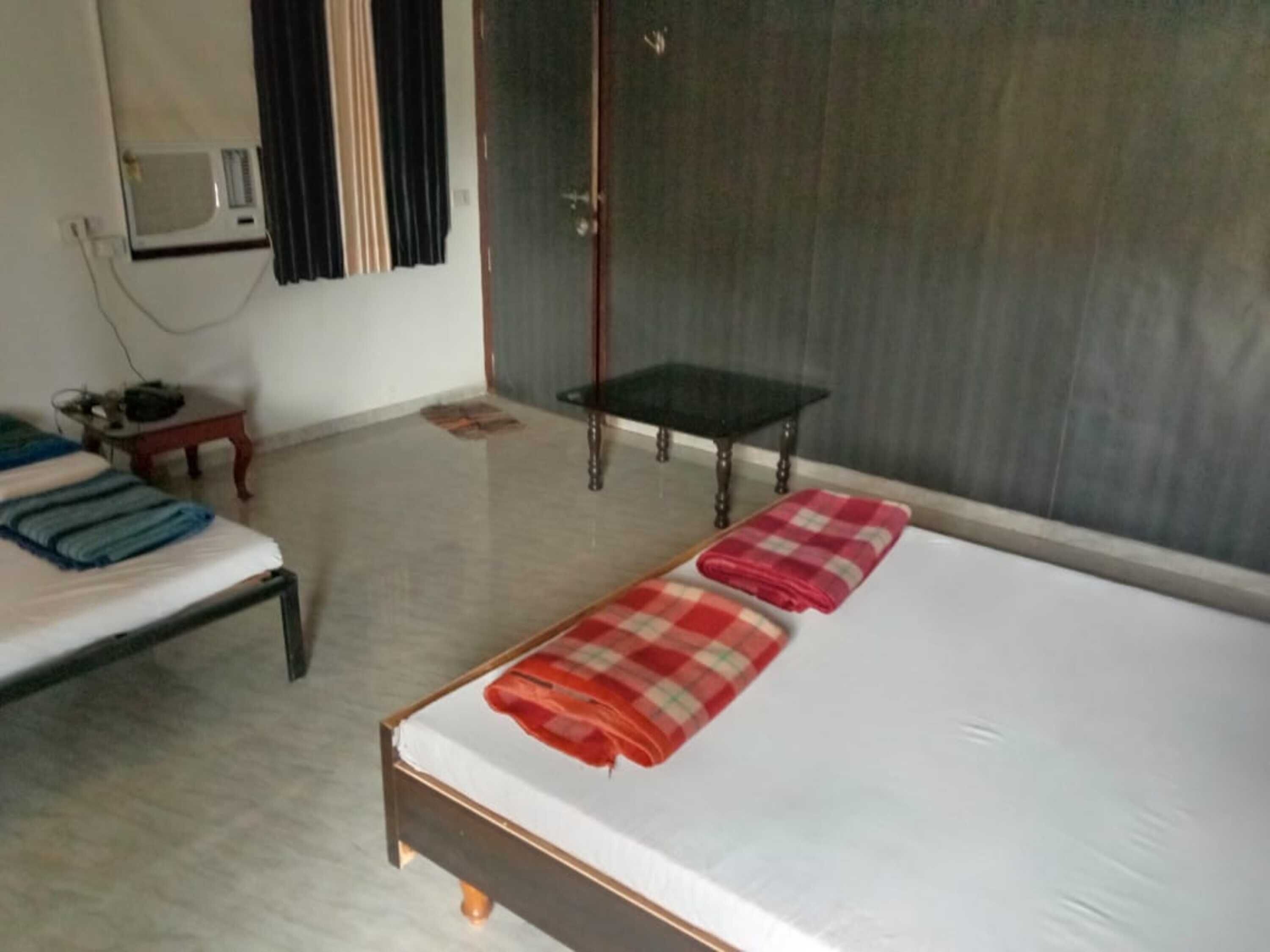 Une chambre d’hôtel avec un lit, une petite table, un four à micro-ondes et une armoire.