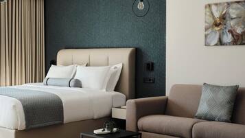 Suite Deluxe, balcone, vista città | Biancheria da letto ipoallergenica, cassaforte in camera, una scrivania