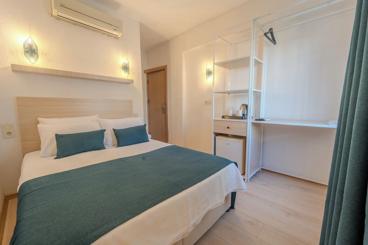 Una habitación de hotel con cama, escritorio y armario.
