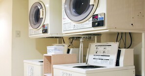 A laundry facility with multiple washing machines and a control panel. - Hotel Pearl City Morioka (Morioka)