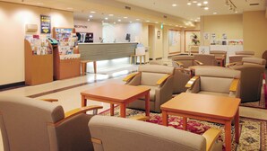 A reception area with a counter, seating, and informational posters. - Hotel Pearl City Morioka (Morioka)