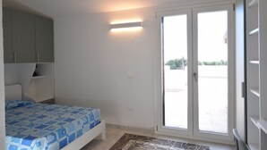 A bedroom with a bed, a wardrobe, a sliding glass door, and a small window. - Wonderful  villa for 7 guests with WIFI, A/C, TV and patio (Budoni)