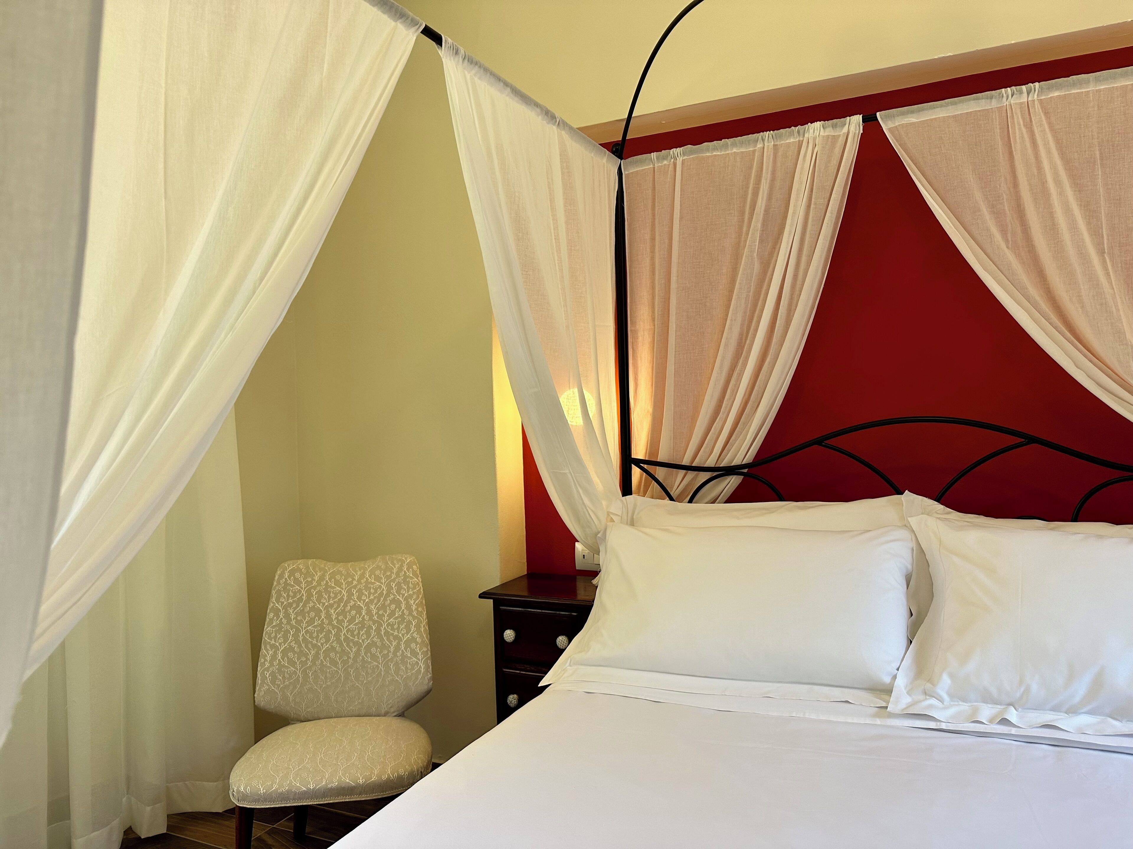 A bed with white bedding, a chair, and a nightstand.