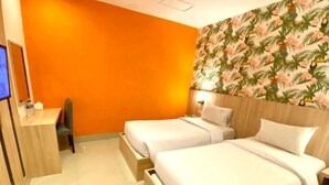 A hotel room with two beds, a wooden desk, a chair, and a TV on the wall. - ALL NITE & DAY Makassar (Makassar)