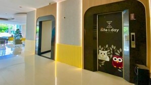 A modern hotel lobby with a clean, minimalist design, featuring a reception area with a 'nite&day' sign and an owl decoration. - ALL NITE & DAY Makassar (Makassar)
