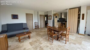 Ein Wohnzimmer mit einer Couch, einem Couchtisch und einem Esstisch mit Stühlen.
