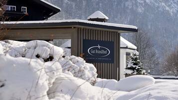 A snow-covered building with a sign reading "Gut Brandhof Hotel & Conference."