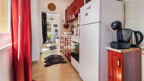 Een moderne keuken met houten kastjes, een witte koelkast en een koffieapparaat.
