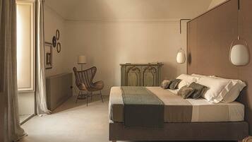 A bedroom with a large bed, a chair, a dresser, and a lamp.