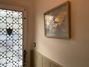 A door with a geometric pattern and a framed world map on the wall. - Charming seaside village house (Vilassar de Mar)
