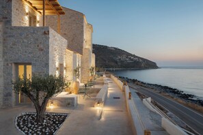 Un edificio de piedra con terraza al aire libre y vistas al mar.