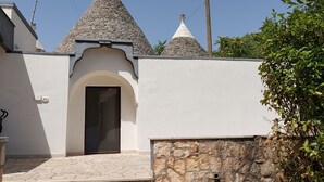 Un bâtiment doté d’une façade en pierre, d’un mur blanc et d’un toit conique.