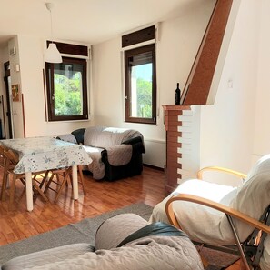 Relax in this inviting room with a high ceiling, large windows, and a comfortable sofa.