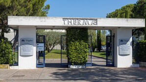 A building entrance with a sign reading "THERMA" and two informational signs on either side.