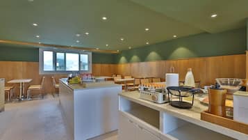 A modern kitchen with a central island, bar stools, and a window overlooking a scenic view.