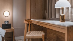 A modern room with a wooden desk, a woven chair, a lamp, and a wall-mounted speaker. - Gridt Hotel (Gyeongju)