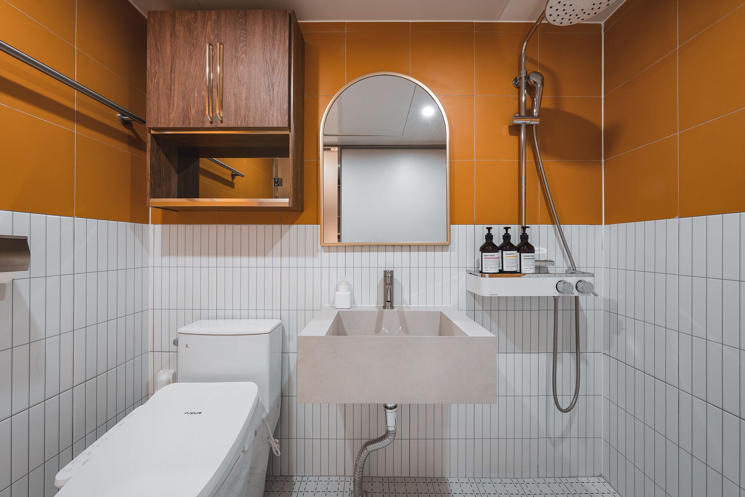 Un baño con inodoro, lavamanos, ducha y espejo.