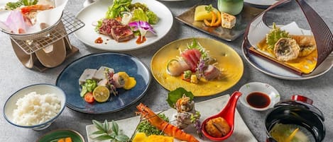 Une variété de plats disposés sur une table, notamment des fruits de mer, des légumes et du riz.