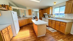 Une cuisine moderne avec des meubles en bois, un îlot central et une grande fenêtre.