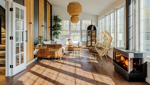 A spacious living room with a fireplace, large windows, and a modern design. - Luna Cove: Premier Hudson Valley Getaway (South Cairo)