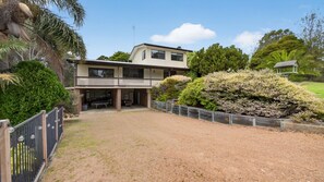 A two-story house with a covered patio and a fenced yard. - Treetop Retreat House | Spacious Family Getaway (Metung)