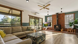 A spacious living room with a sofa, ottoman, and a fireplace.